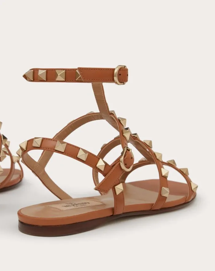 Valentino Sandals Woman Rockstud Flat Calfskin Sandal With Straps For Woman In Poudre Poudre