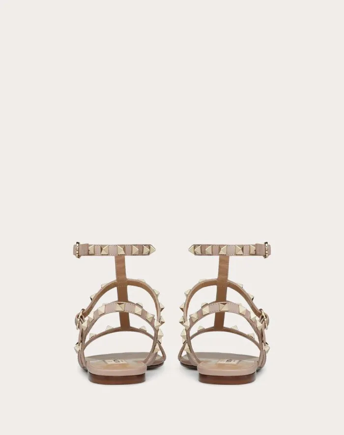 Valentino Sandals Woman Rockstud Flat Calfskin Sandal With Straps For Woman In Poudre Poudre